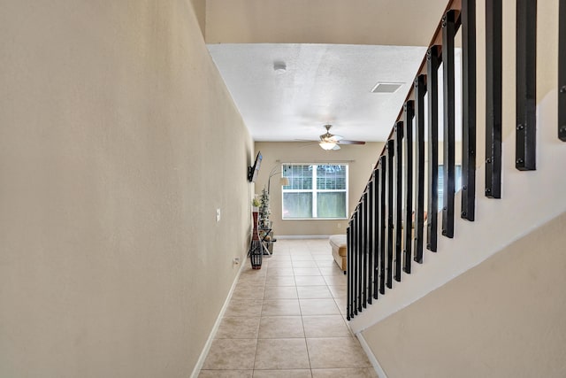 staircase featuring tile patterned flooring and ceiling fan