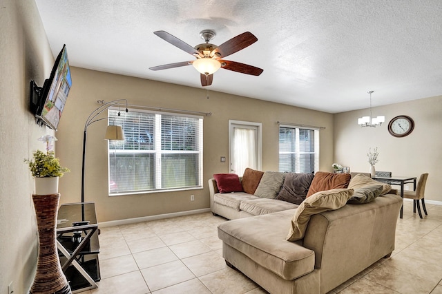 living room featuring a textured ceiling, light tile patterned flooring, and ceiling fan with notable chandelier