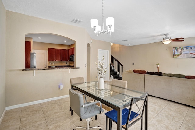 dining room with light tile patterned floors and ceiling fan with notable chandelier