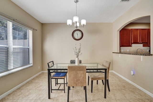 tiled dining room with sink and an inviting chandelier