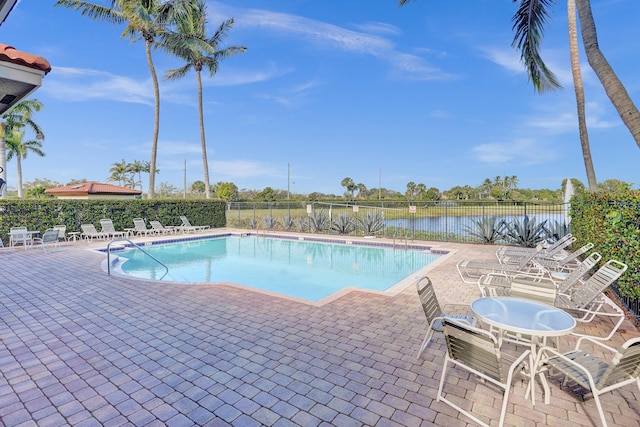 view of pool with a water view and a patio area