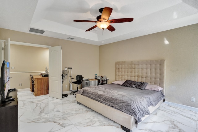 bedroom featuring a tray ceiling and ceiling fan