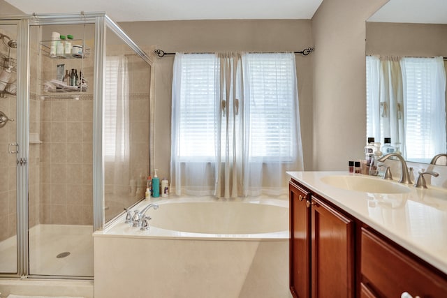 bathroom with vanity, a healthy amount of sunlight, and plus walk in shower