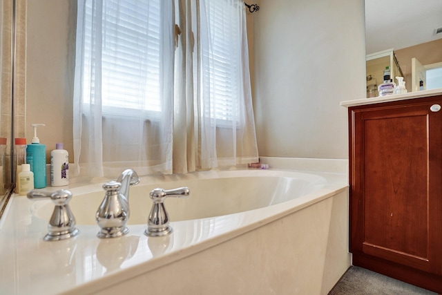 bathroom with vanity and a tub to relax in