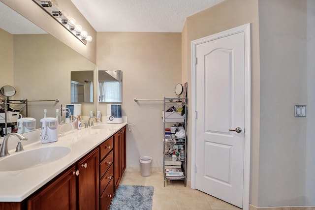 bathroom with tile patterned floors, vanity, and a textured ceiling