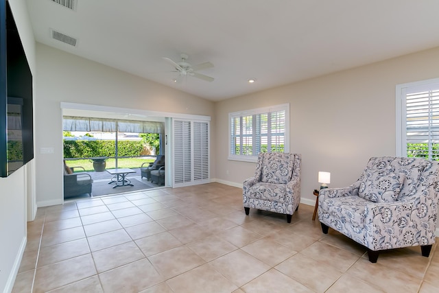 sitting room with ceiling fan, light tile patterned floors, and vaulted ceiling