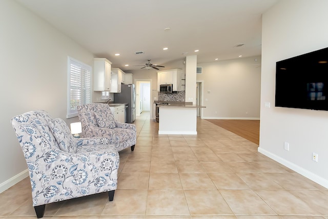 tiled living room with ceiling fan and sink