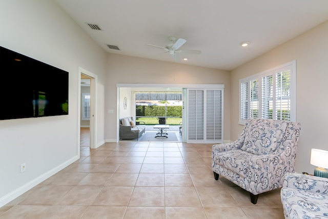 living area with ceiling fan, light tile patterned floors, and vaulted ceiling