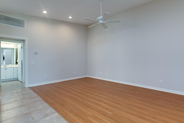 tiled spare room with ceiling fan