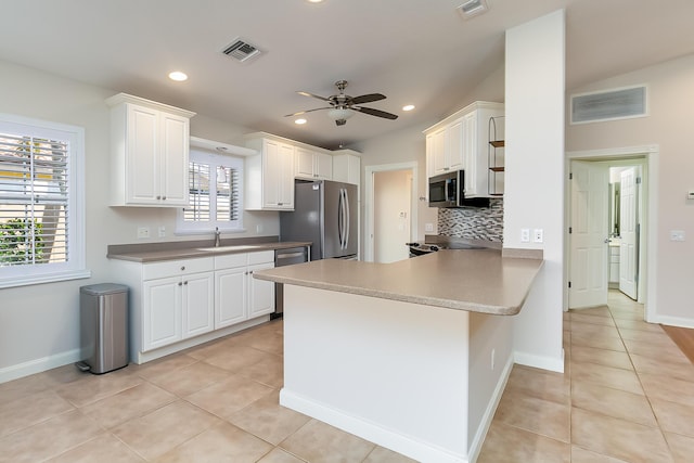 kitchen with kitchen peninsula, sink, white cabinets, and stainless steel appliances