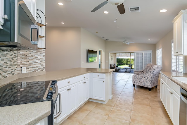 kitchen with ceiling fan, light tile patterned floors, white cabinetry, kitchen peninsula, and stainless steel appliances