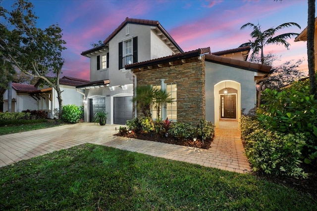 mediterranean / spanish house featuring a garage and a yard