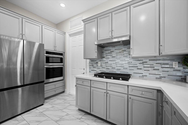 kitchen featuring gray cabinetry, decorative backsplash, and stainless steel appliances