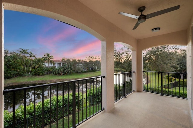 balcony at dusk featuring ceiling fan