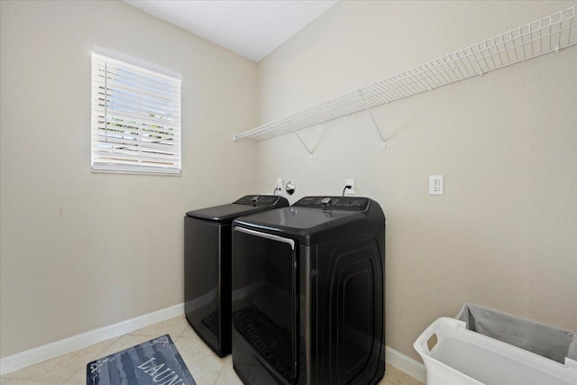 laundry area featuring light tile patterned floors and washing machine and dryer