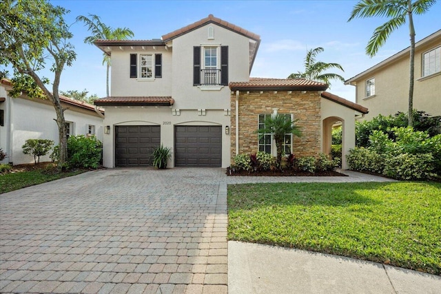 mediterranean / spanish house featuring a front yard and a garage