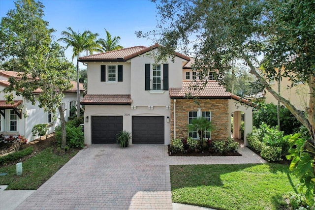 mediterranean / spanish-style house featuring a garage and a front yard