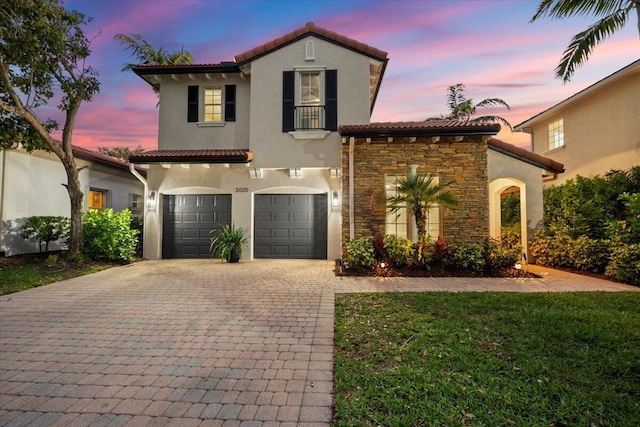 mediterranean / spanish home with a lawn, a balcony, and a garage