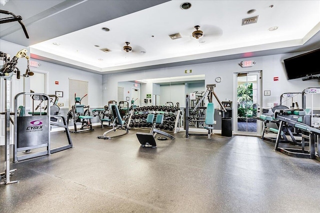 workout area with a raised ceiling and ceiling fan