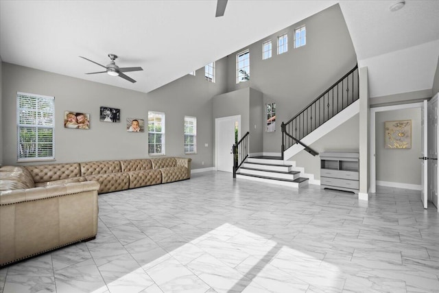 living room featuring a towering ceiling and ceiling fan