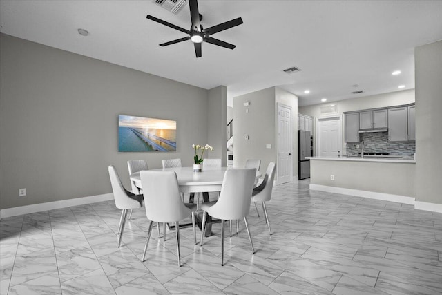 dining area with ceiling fan and sink