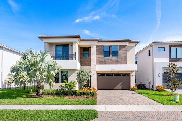 view of front of home with a front yard, a balcony, and a garage