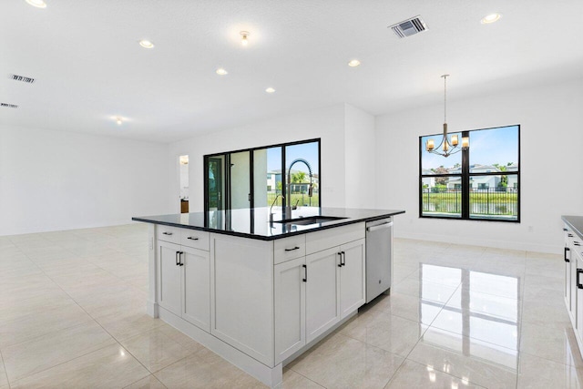 kitchen featuring an inviting chandelier, sink, stainless steel dishwasher, an island with sink, and white cabinetry