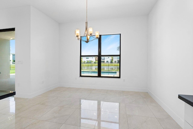 empty room featuring a notable chandelier and light tile patterned floors