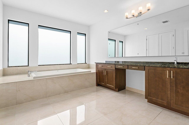 bathroom featuring tile patterned floors, vanity, and tiled bath