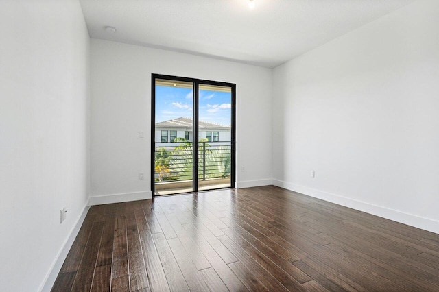 empty room with dark hardwood / wood-style flooring