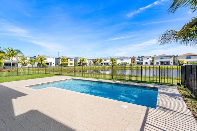 view of swimming pool featuring a yard, a water view, and a patio