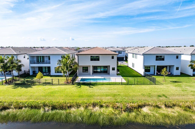 back of property with a lawn and a fenced in pool