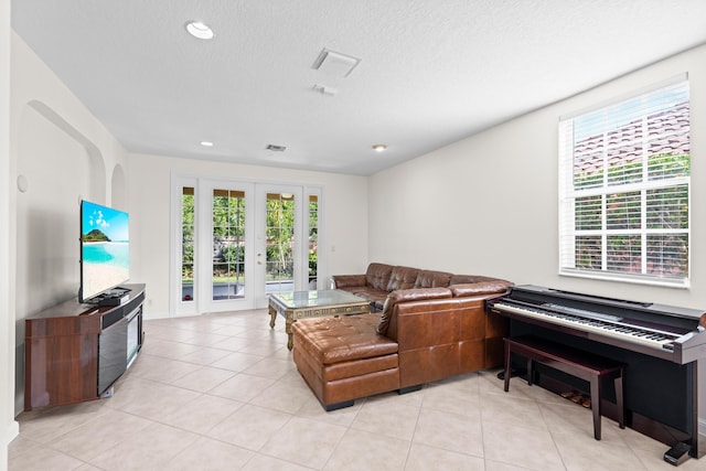 living room with a textured ceiling and light tile patterned flooring