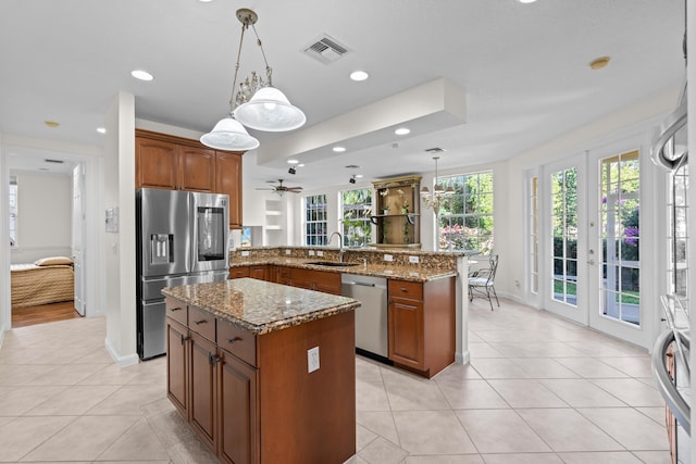 kitchen featuring pendant lighting, sink, a center island, kitchen peninsula, and stainless steel appliances