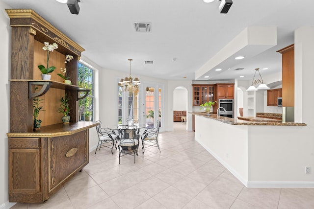 dining room with light tile patterned floors and a chandelier