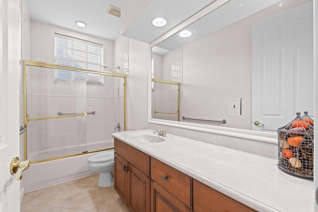 full bathroom featuring tile patterned flooring, vanity, enclosed tub / shower combo, and toilet