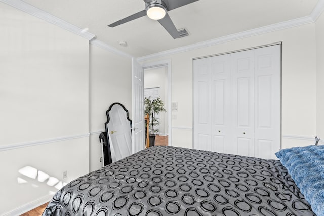 bedroom with hardwood / wood-style floors, ornamental molding, a closet, and ceiling fan