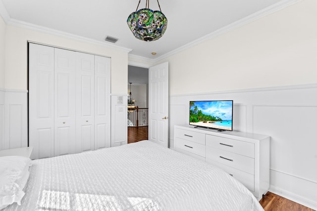 bedroom featuring crown molding, hardwood / wood-style floors, and a closet