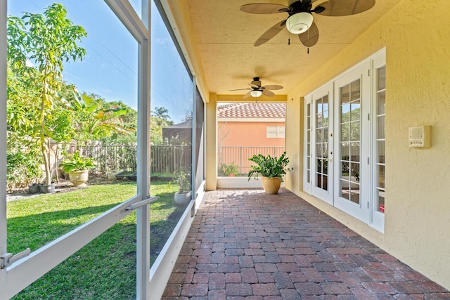 unfurnished sunroom with ceiling fan