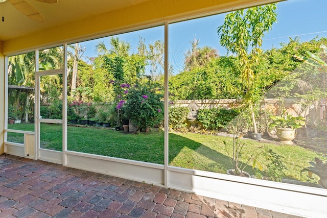 unfurnished sunroom featuring ceiling fan