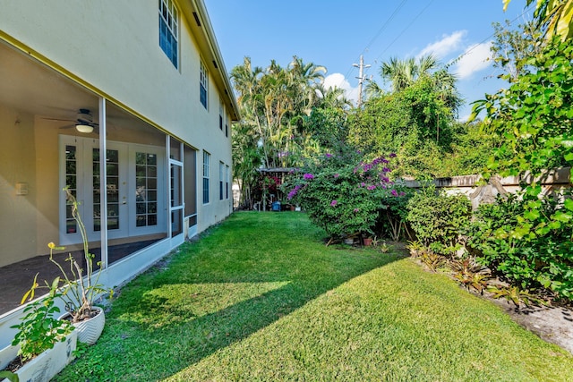 view of yard featuring ceiling fan and french doors