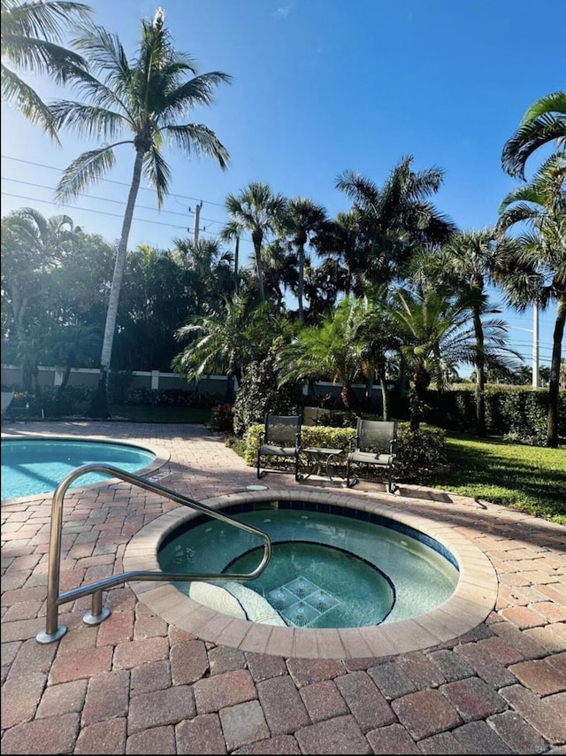 view of swimming pool featuring an in ground hot tub and a patio