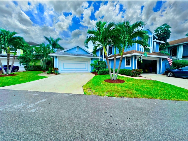 view of front of property featuring driveway, a front yard, and a garage