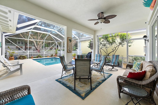 view of pool with ceiling fan, a lanai, and a patio