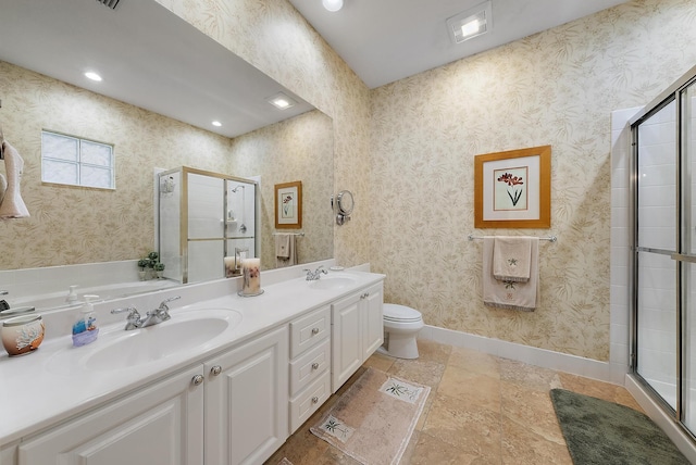 bathroom featuring a shower with shower door, vanity, and toilet