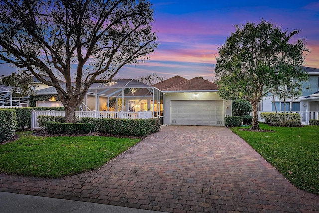 ranch-style house featuring a garage and a lawn