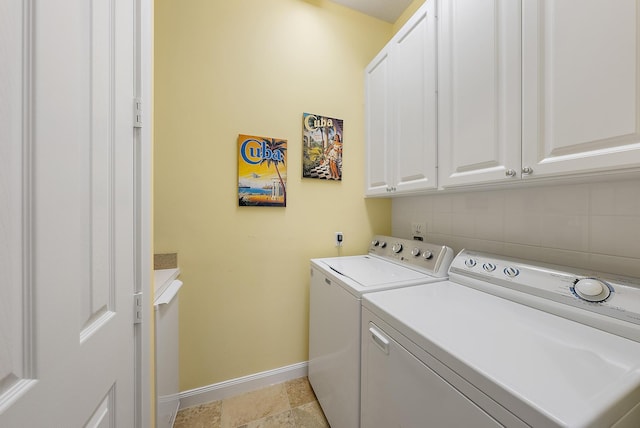 clothes washing area featuring cabinets and separate washer and dryer