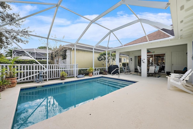 view of pool featuring ceiling fan, a patio, and glass enclosure