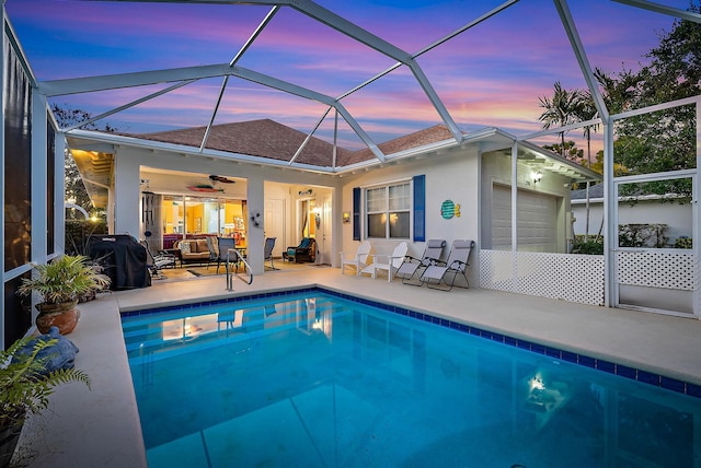 pool at dusk with ceiling fan, a patio area, a lanai, and grilling area