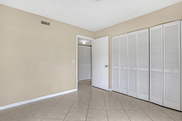 unfurnished bedroom with light tile patterned flooring and a closet